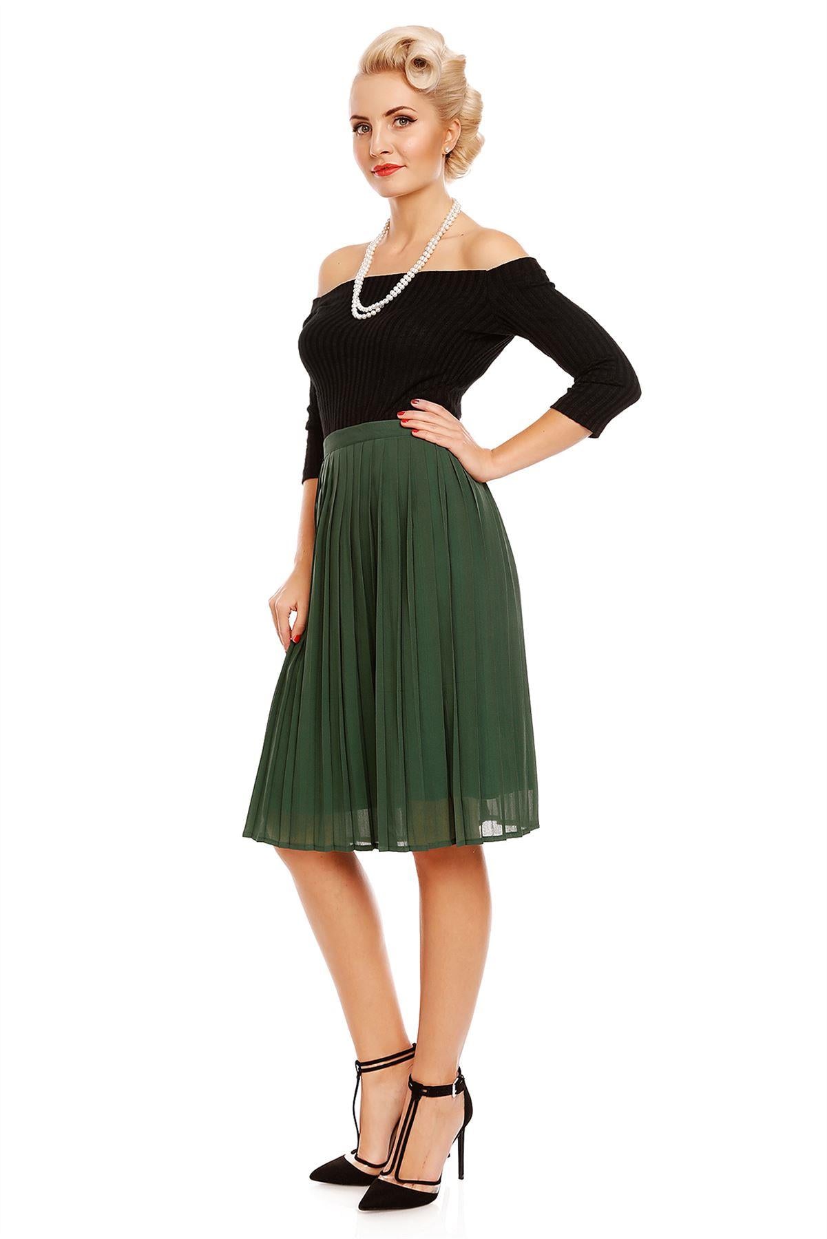 Model wearing our Gloria off-shoulder long sleeve top in black, with a green skirt, side view