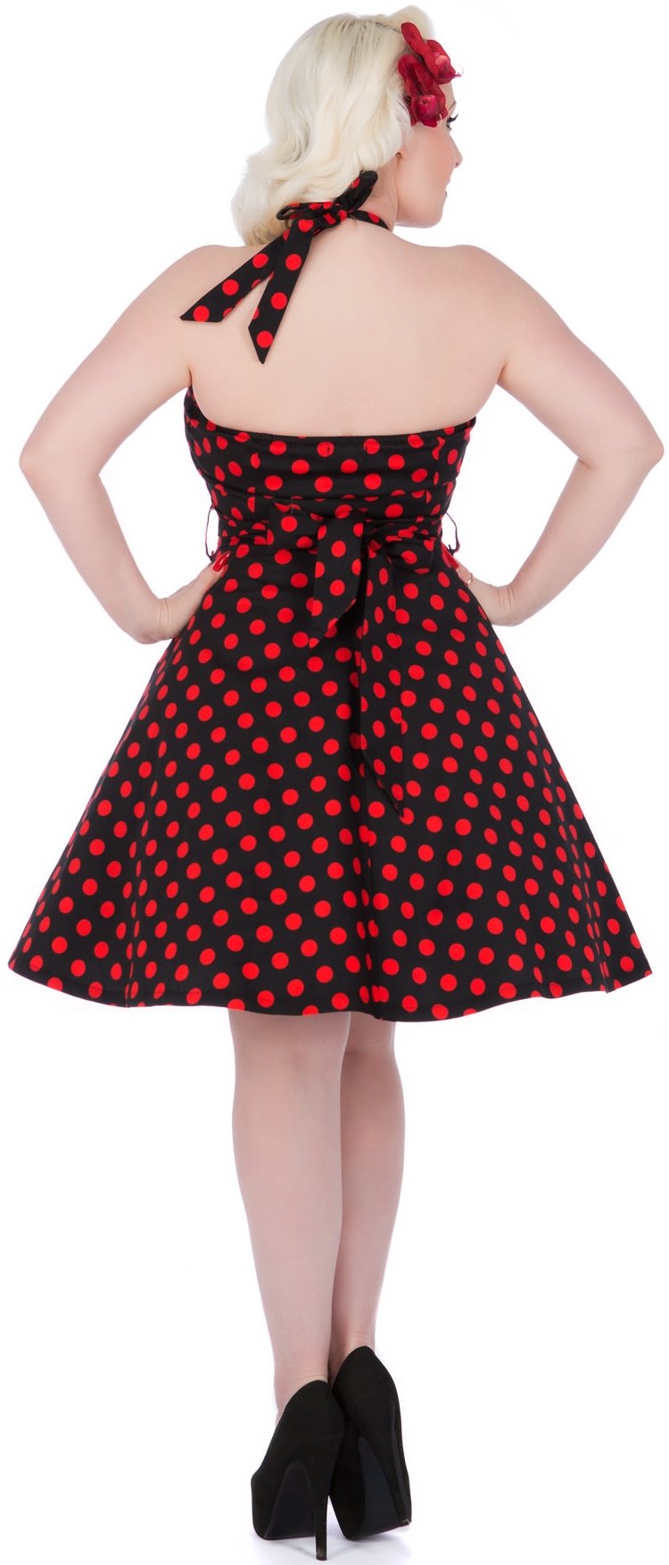 Model wearing black and red polka dot halterneck dress, back view