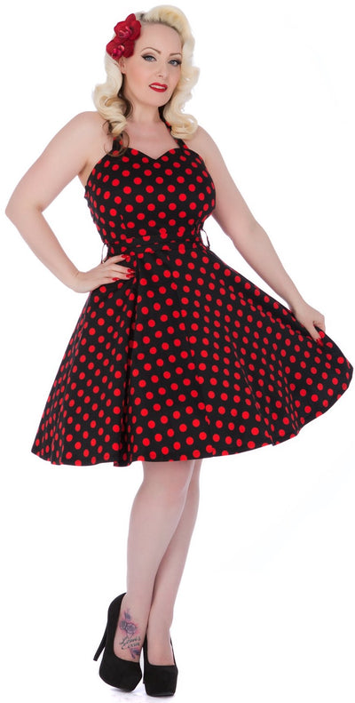 Model wearing black and red polka dot halterneck dress, front view