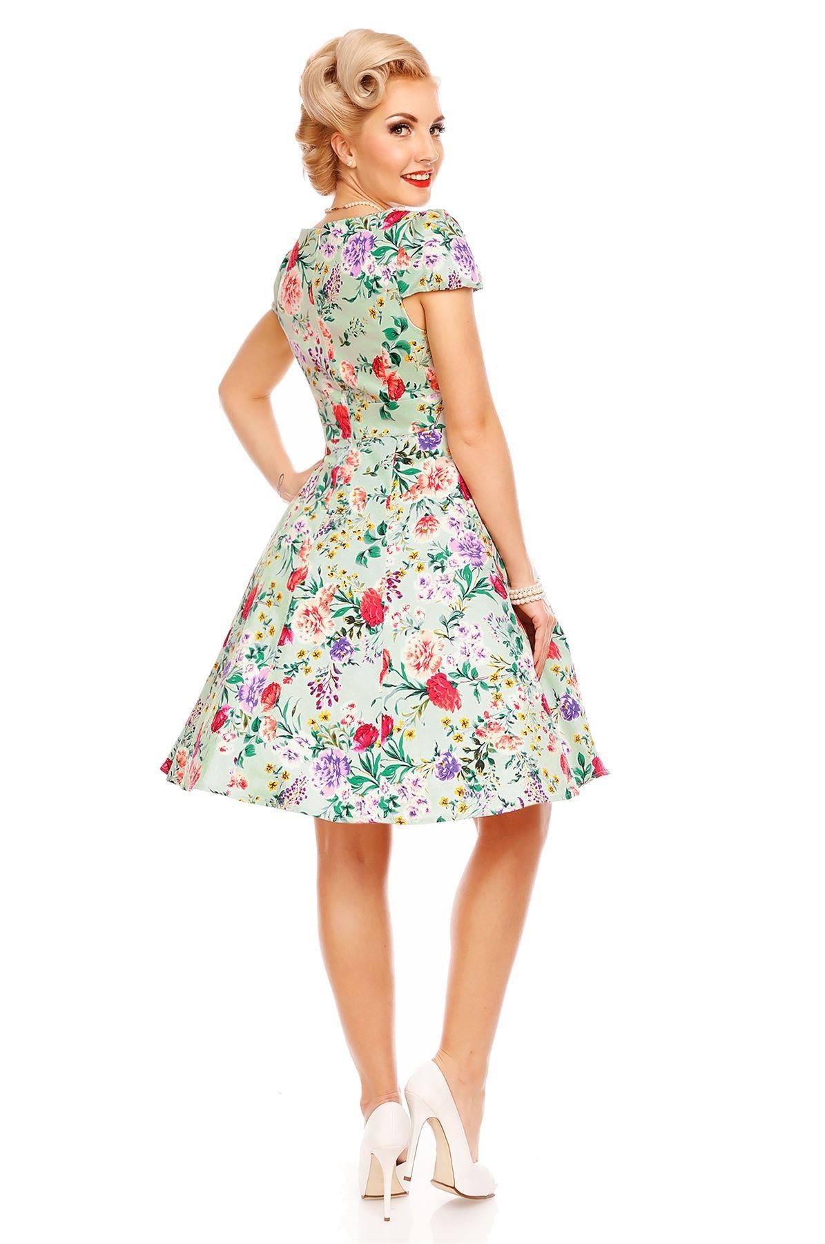 Model wearing Claudia, our short sleeve dress, in green, pink floral print, back view