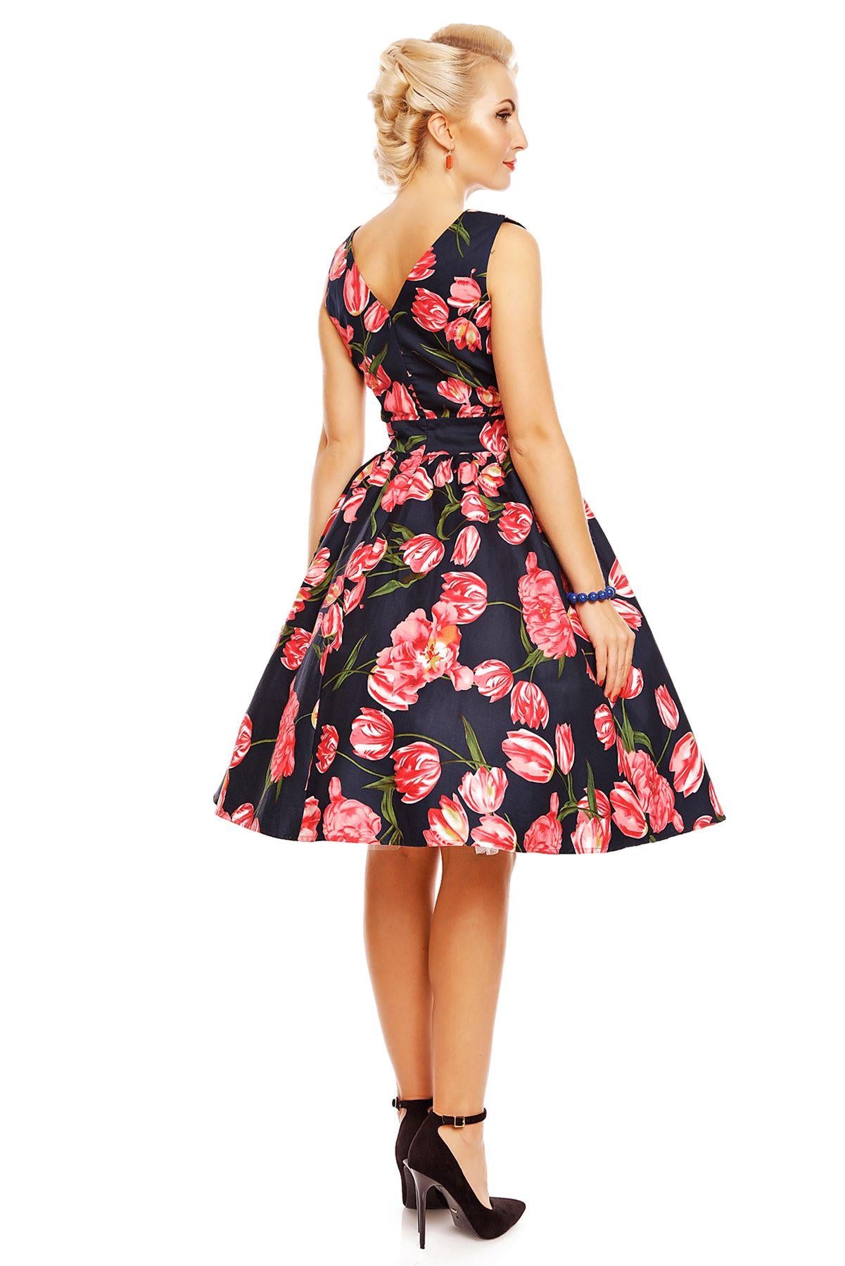 Model wearing May V neck floral dress, in navy blue, with pink tulips, back view