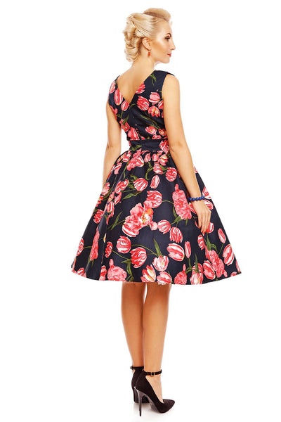 Model wearing May V neck floral dress, in navy blue, with pink tulips, back view