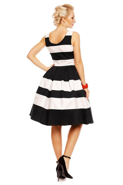 Model wears the black and white striped Annie swing dress, with embroidered red rose on the skirt, back view