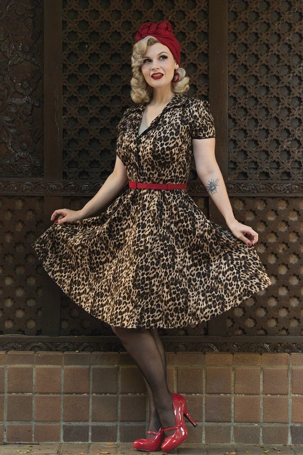 Model wears our short sleeve Penelope dress, in brown leopard print, in a street