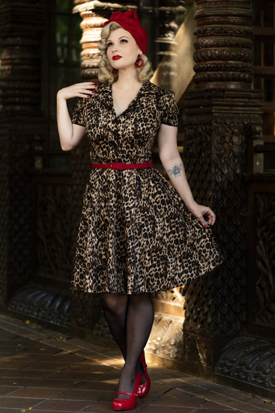 Model wears our short sleeve Penelope dress, in brown leopard print, in a street