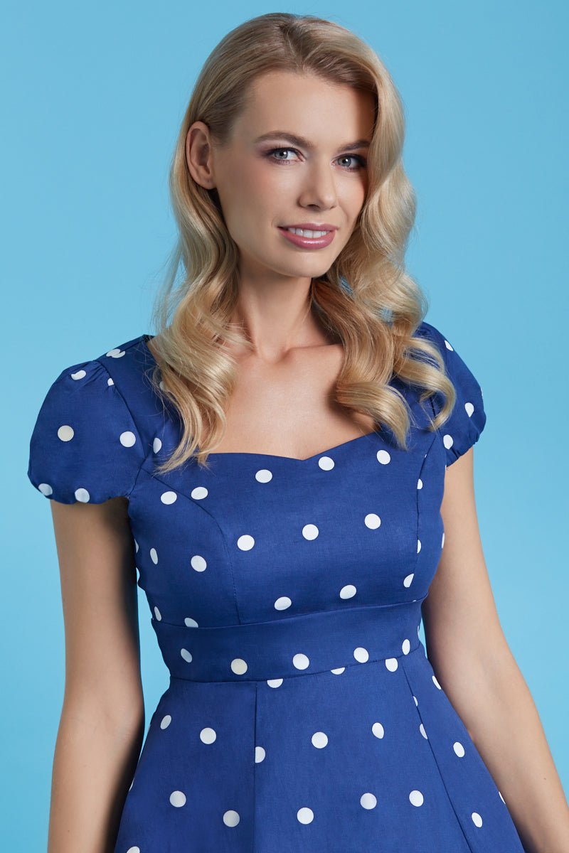 Model wears the dark blue Claudia dress, with white polka dots, close up  view
