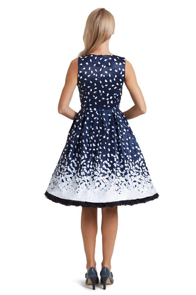 Model wears our sleeveless Annie swing dress, in navy blue, with white brushstrokes, back view