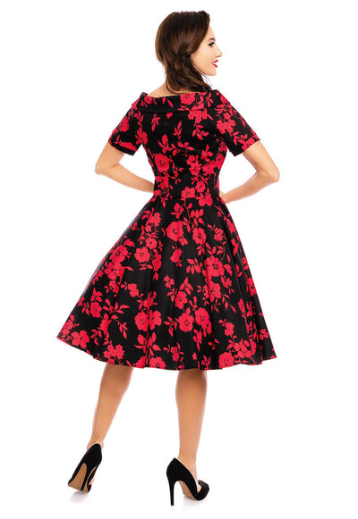 Model wearing our bateau neckline Darlene dress, in black/red floral print, back view