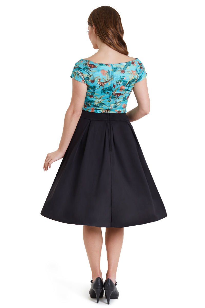 Model wearing blue dinosaur/pterosaur print top, with black skirt, back view