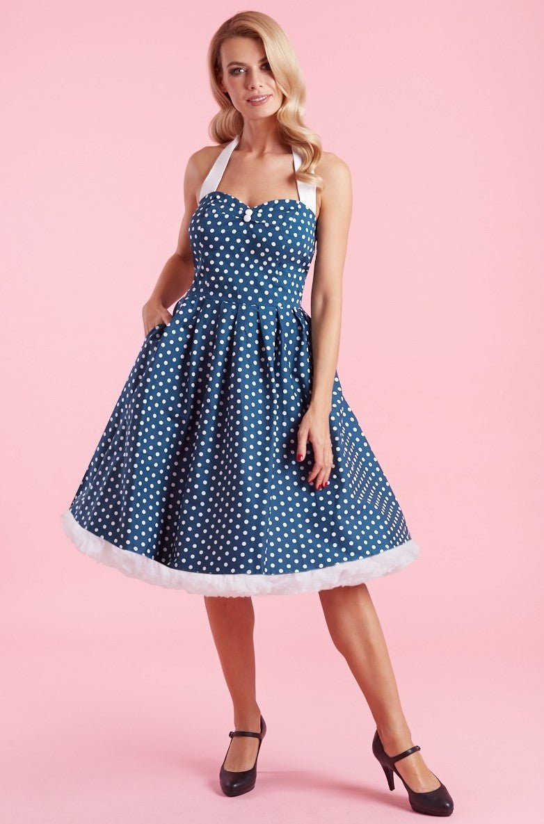 Model wears our halterneck Sophia dress, in blue, with white polka dots, front view
