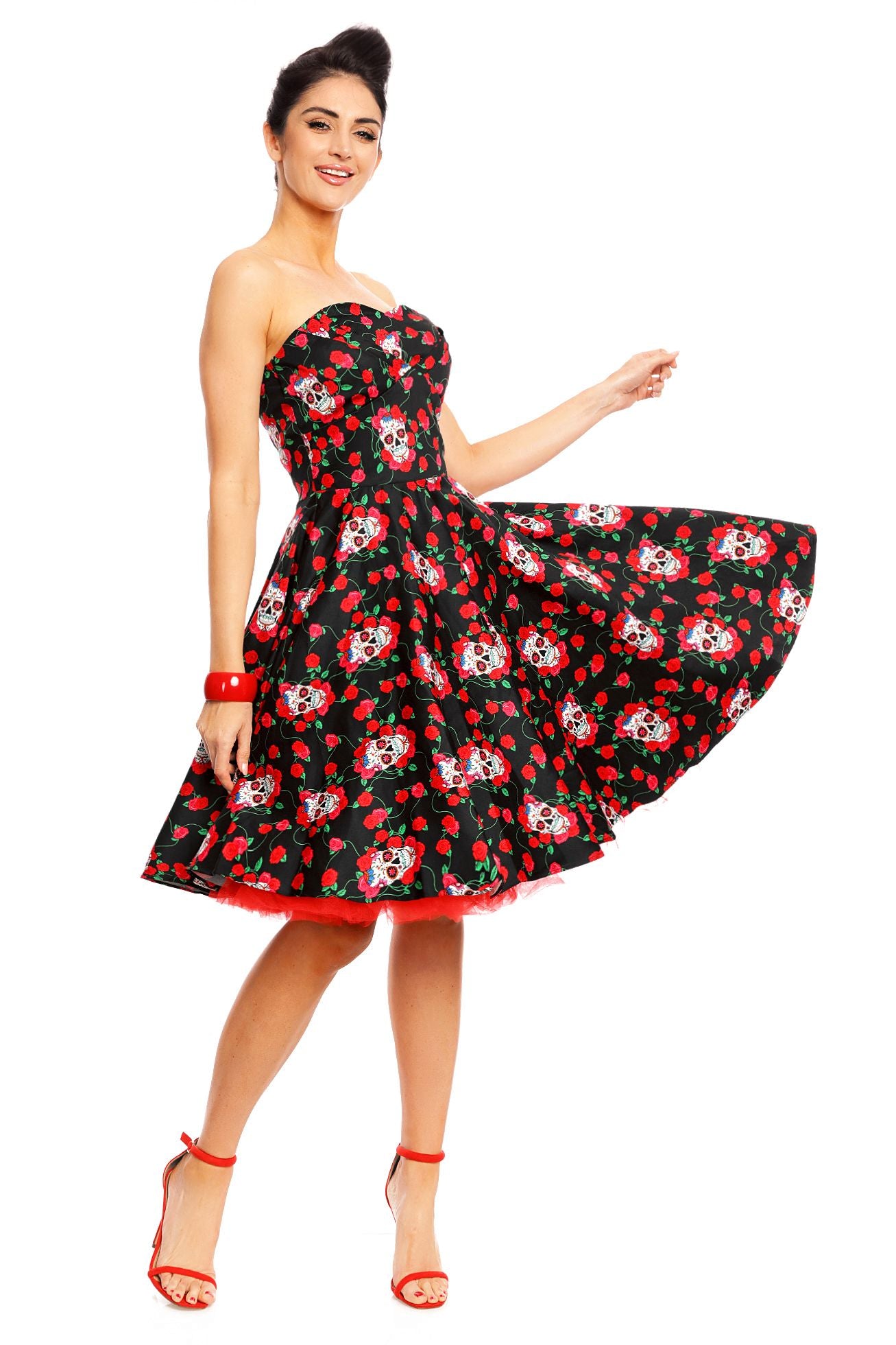 Model wearing the strapless Melissa dress, in black, with red roses and white sugar skulls, with red petticoat,  twirl view