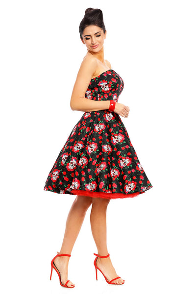 Model wearing the strapless Melissa dress, in black, with red roses and white sugar skulls, side view