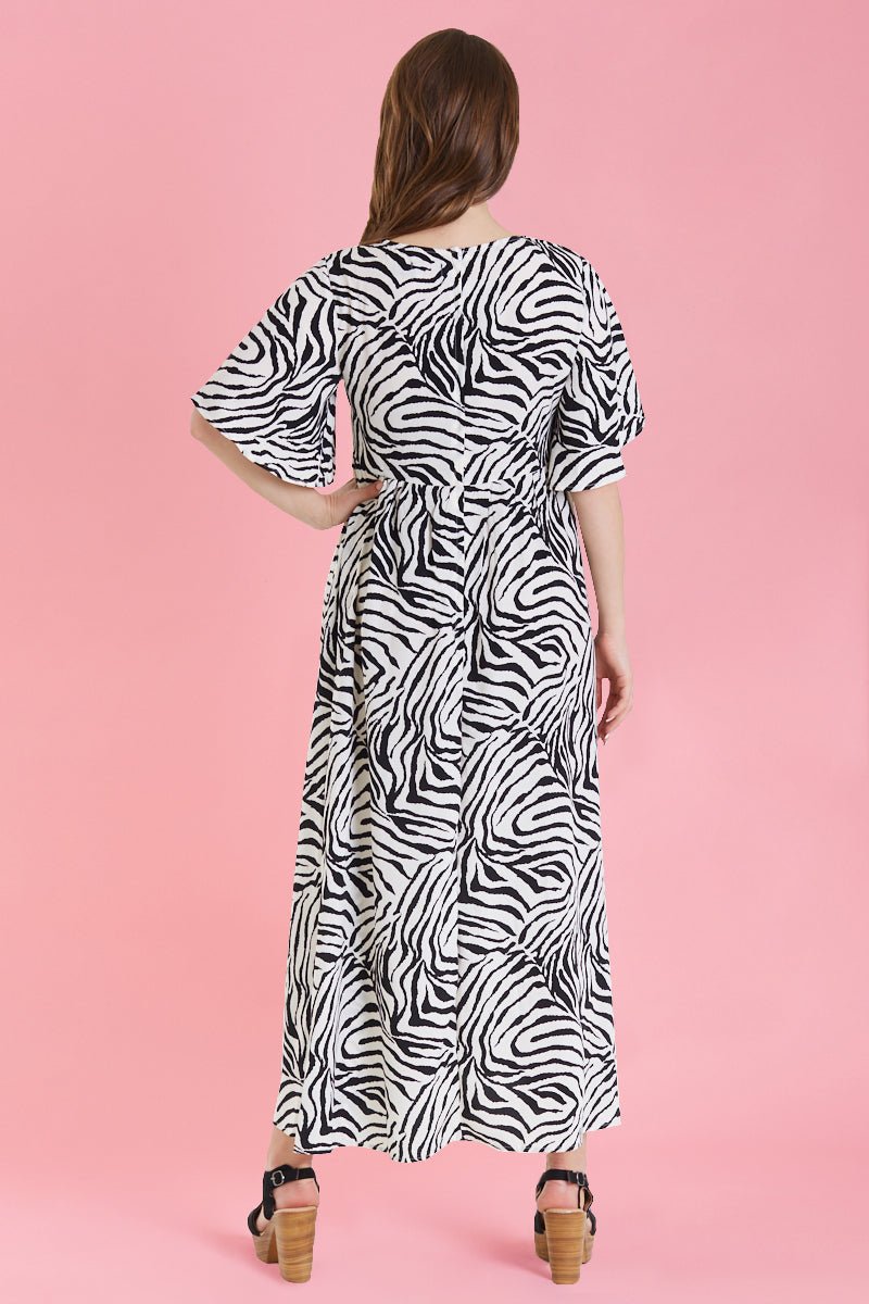 Model in sleeved floaty maxi dress in zebra print back view