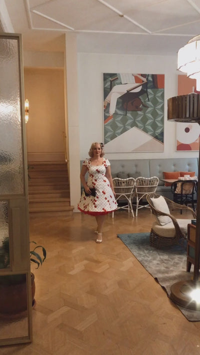 Video of a model twirling and wearing a White Swing Dress with Cherry and Black Polka print.