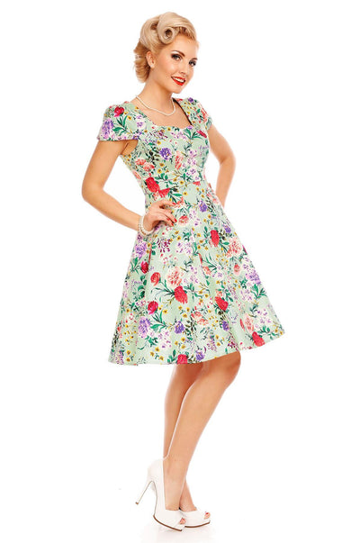 Model wearing Claudia, our short sleeve dress, in green, pink floral print, side view