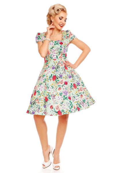 Model wearing Claudia, our short sleeve dress, in green, pink floral print, front view