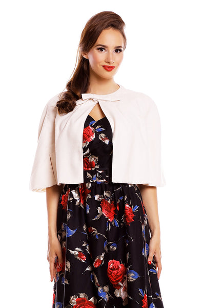 Model wearing our Sabrina cape in beige, with a floral dress underneath, close up view