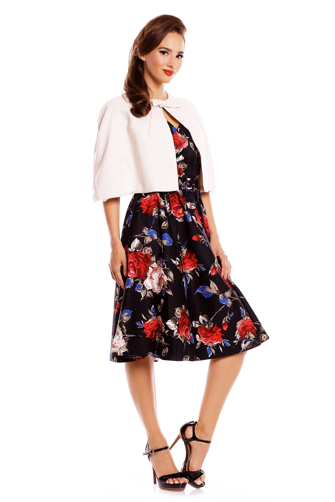 Model wearing our Sabrina cape in beige, with a floral dress underneath, side view
