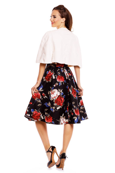 Model wearing our Sabrina cape in beige, with a floral dress underneath, back view