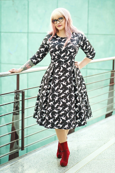 Customer wears our long sleeved flared midi dress, in black and white cat print