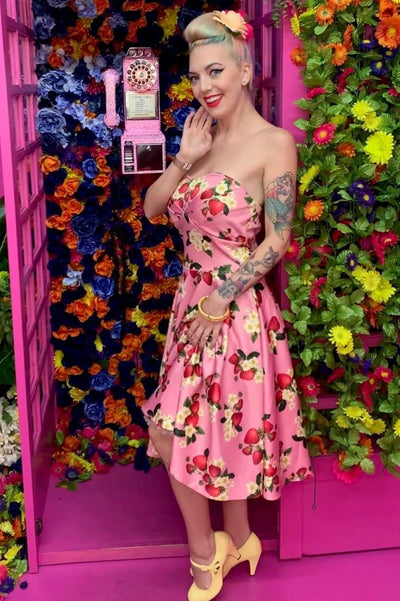 Model wearing strapless swing dress in pink strawberry print