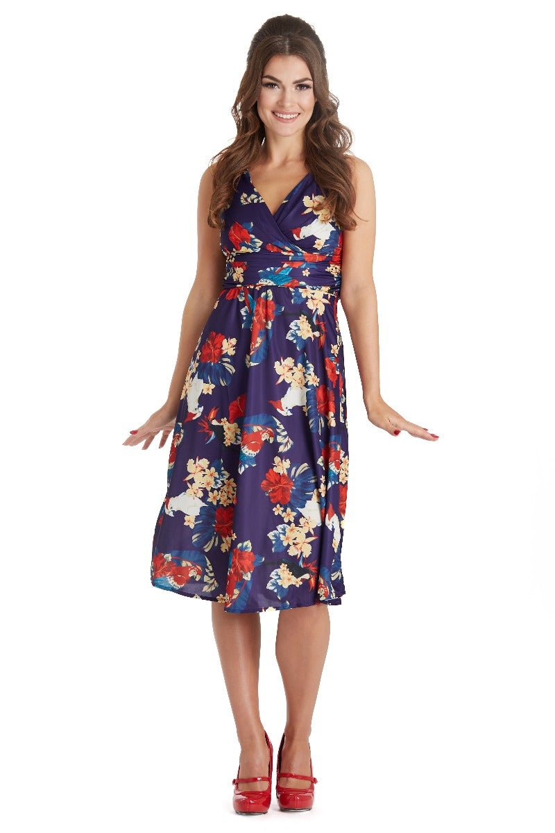Model wears our Bernice sleeveless swing dress in navy blue, with red and white flowers and parrots, front view