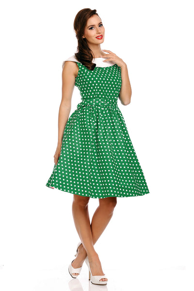 Model wearing our Cindy sleeveless dress, in green/white polka dot print, side view