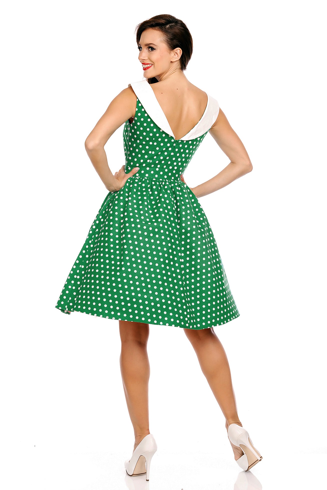 Model wearing our Cindy sleeveless dress, in green/white polka dot print, back view