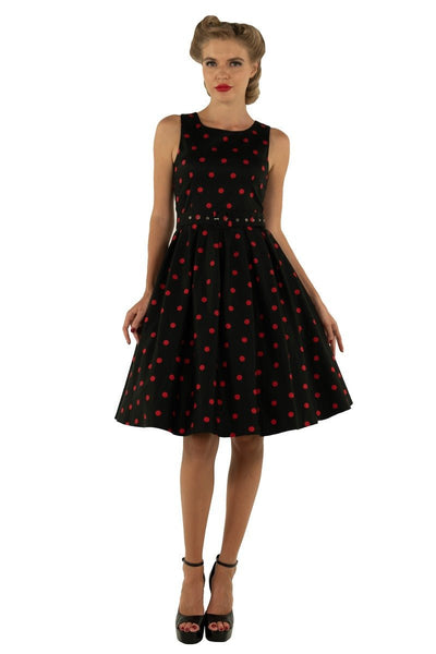 Model wears our Annie swing dress, in black, with red polka dots, front view