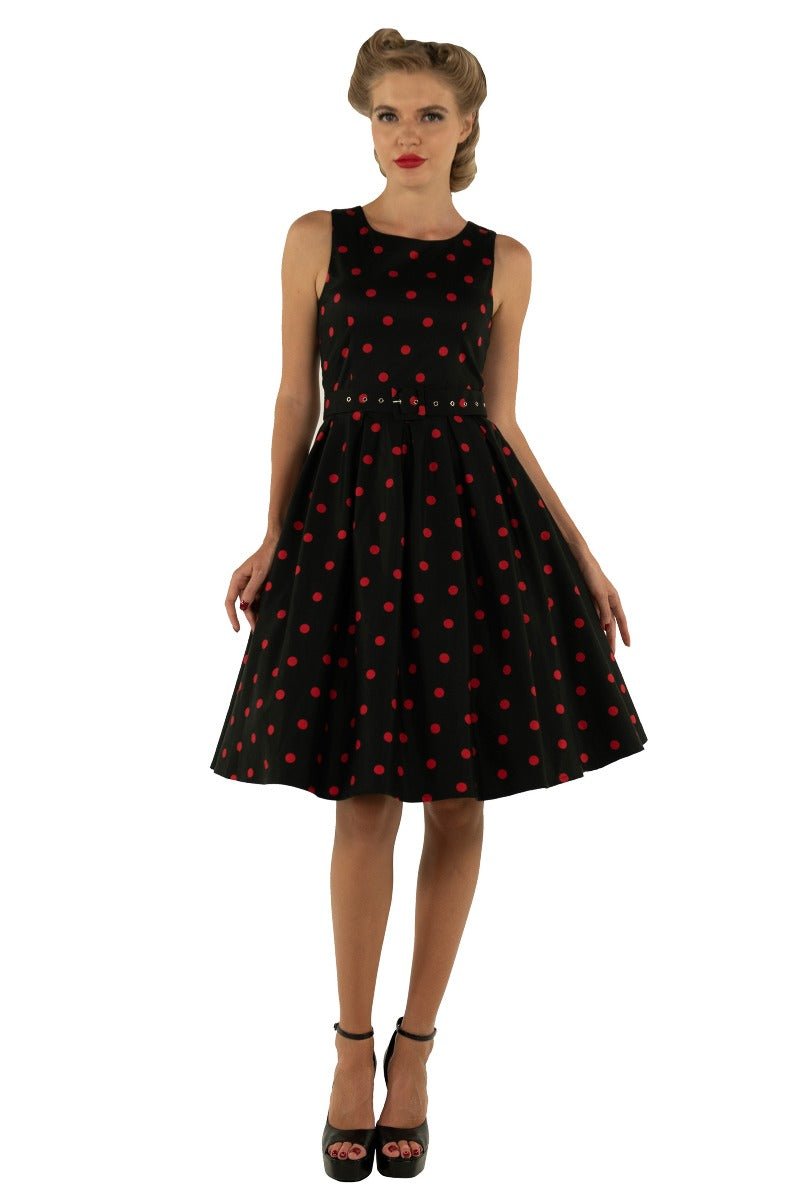 Model wears our Annie swing dress, in black, with red polka dots, front view