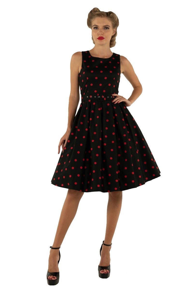 Model wears our Annie swing dress, in black, with red polka dots, front view