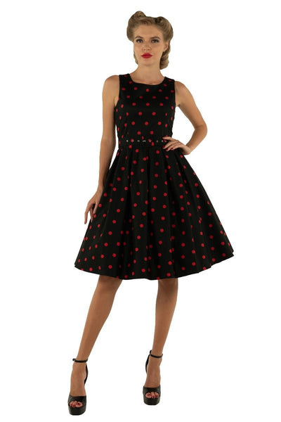 Model wears our Annie swing dress, in black, with red polka dots, front view