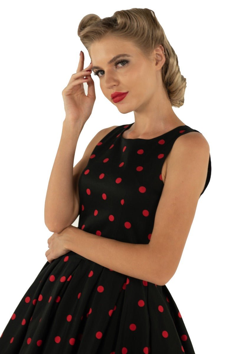 Model wears our Annie swing dress, in black, with red polka dots, close up view