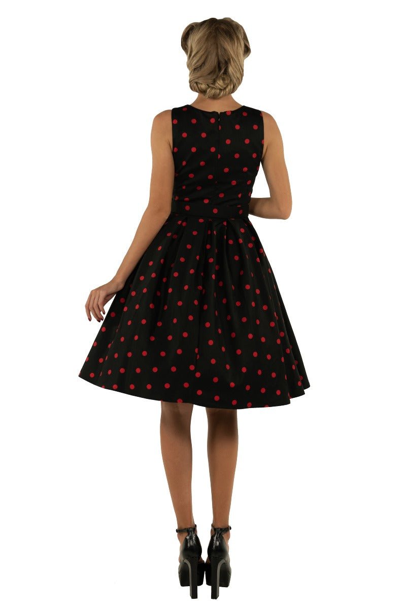Model wears our Annie swing dress, in black, with red polka dots, back view