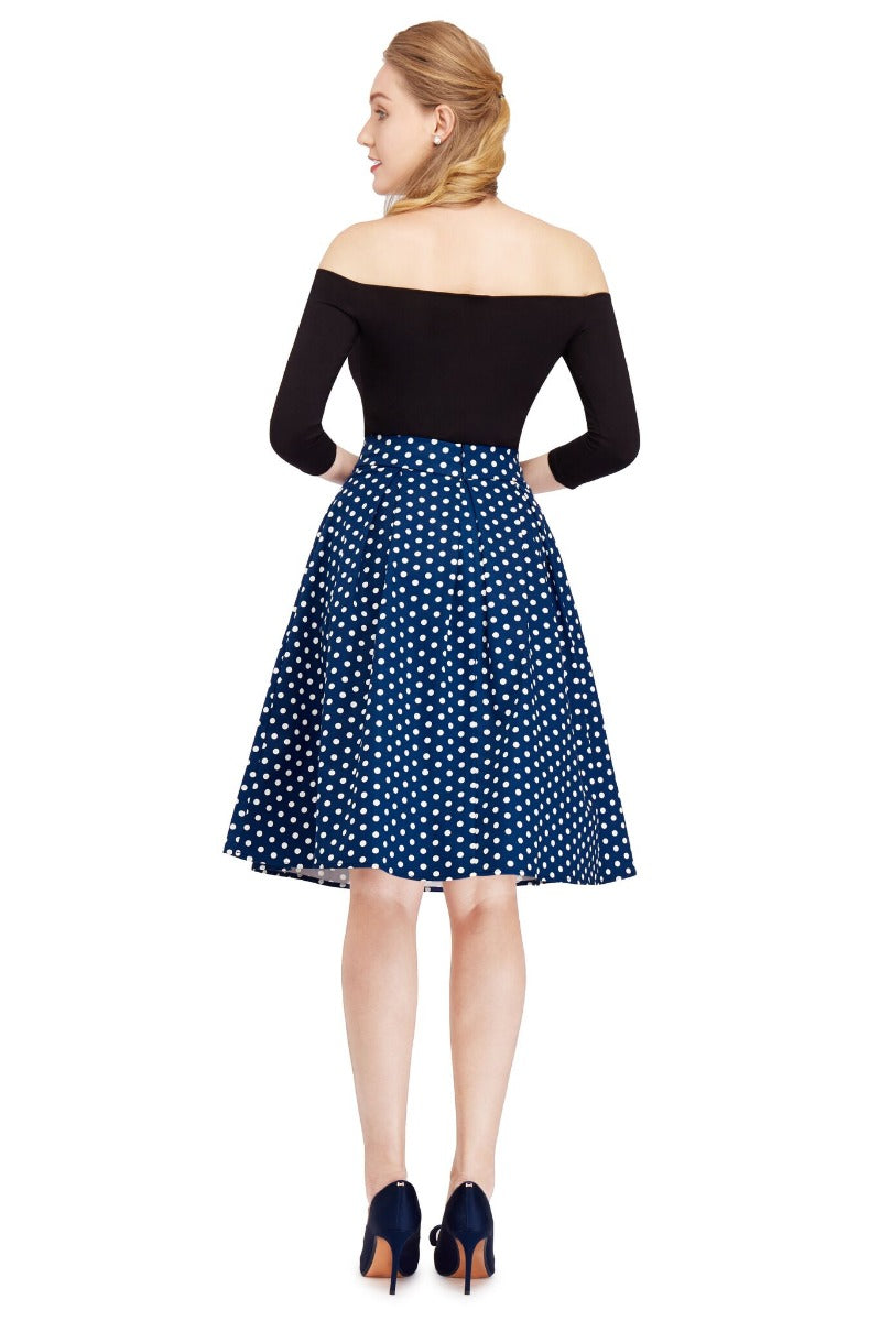 Model wears our black top and dark blue polka dot flared skirt, back view