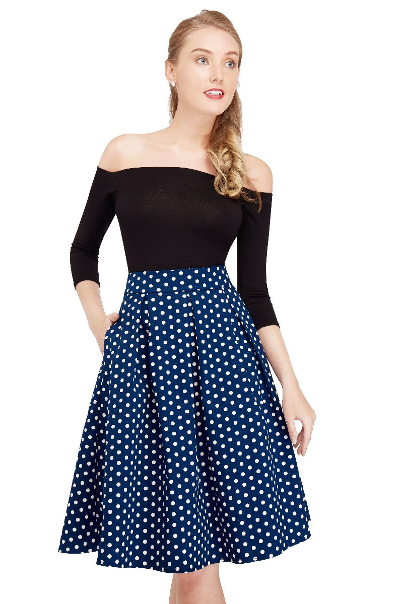 Model wears our black top and dark blue polka dot flared skirt, close up view