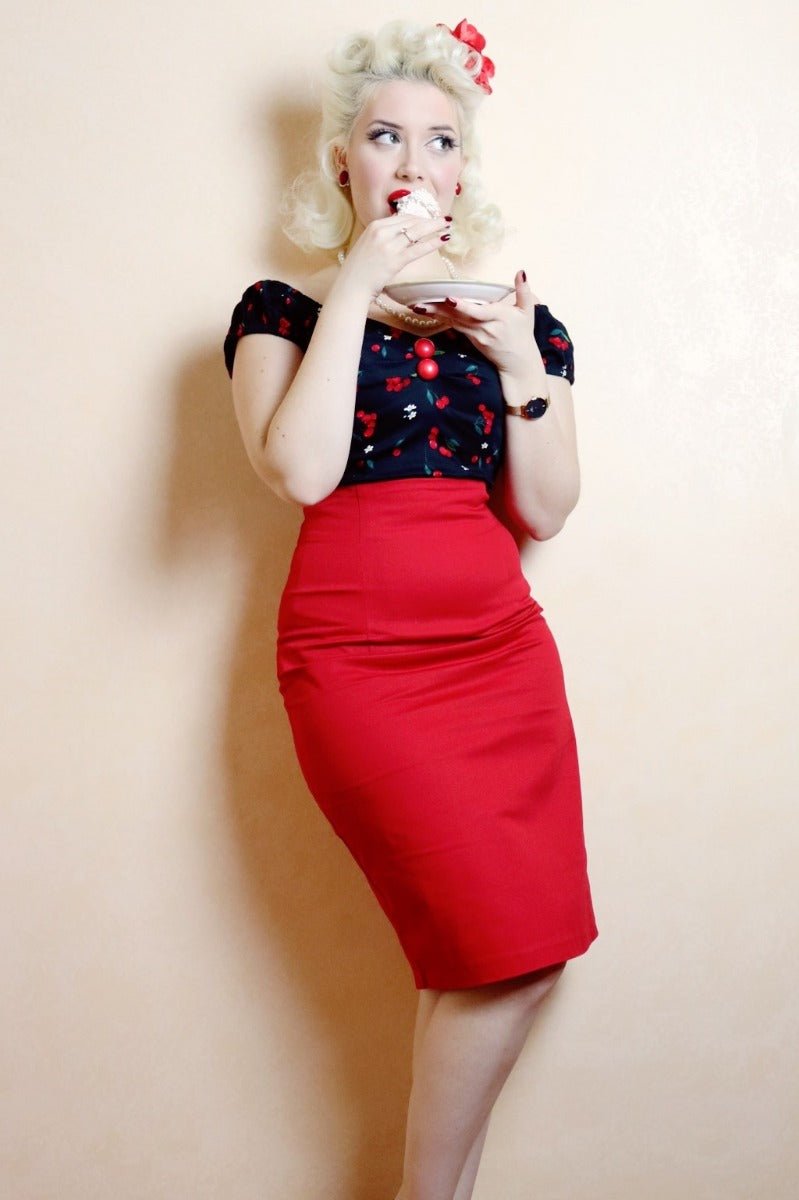 Miss Lady Noir wears our falda pencil skirt, in burgundy red, with a top, whilst eating cake