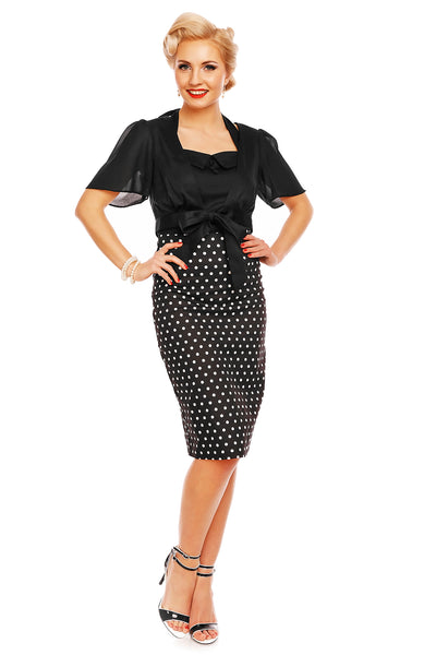 Model wearing our black white polka dot Falda pencil skirt, with a black top and accessories, front view