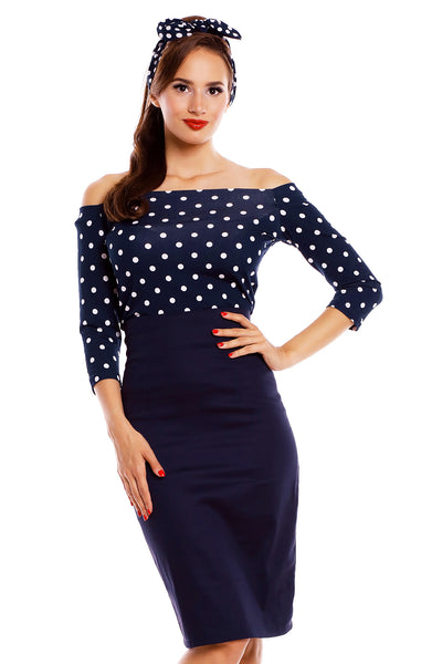 Model wearing our Gloria off-shoulder top, in navy blue, with white polka dots, with matching headband and skirt, front view
