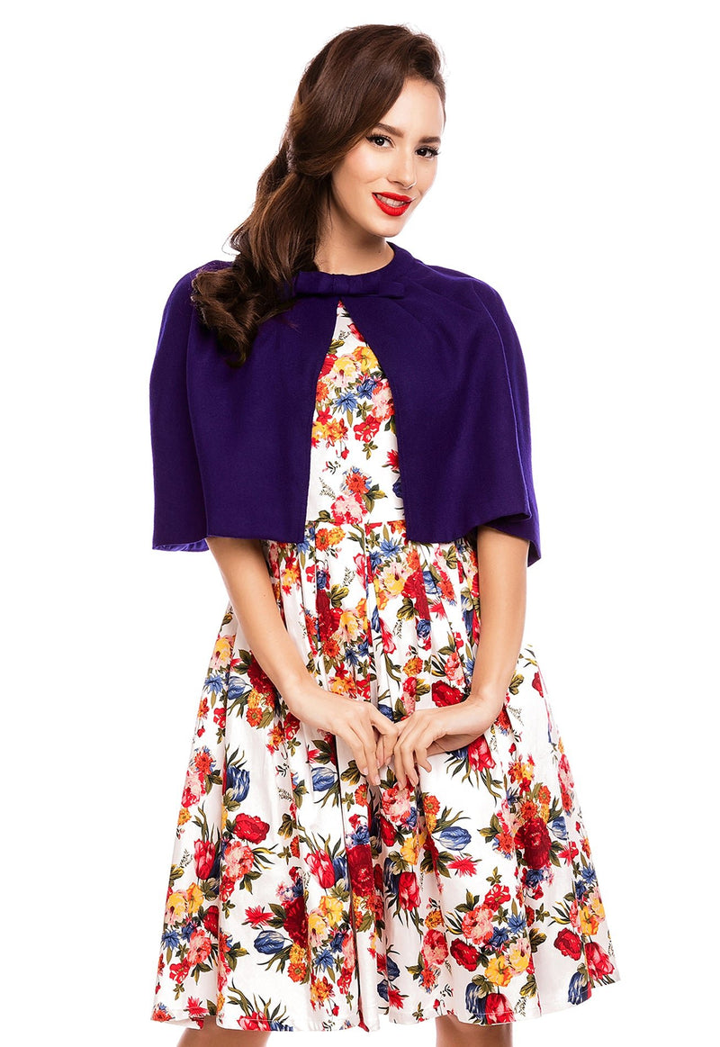 Model wearing our dark blue Sabrina cape shrug, over a white floral dress, front view