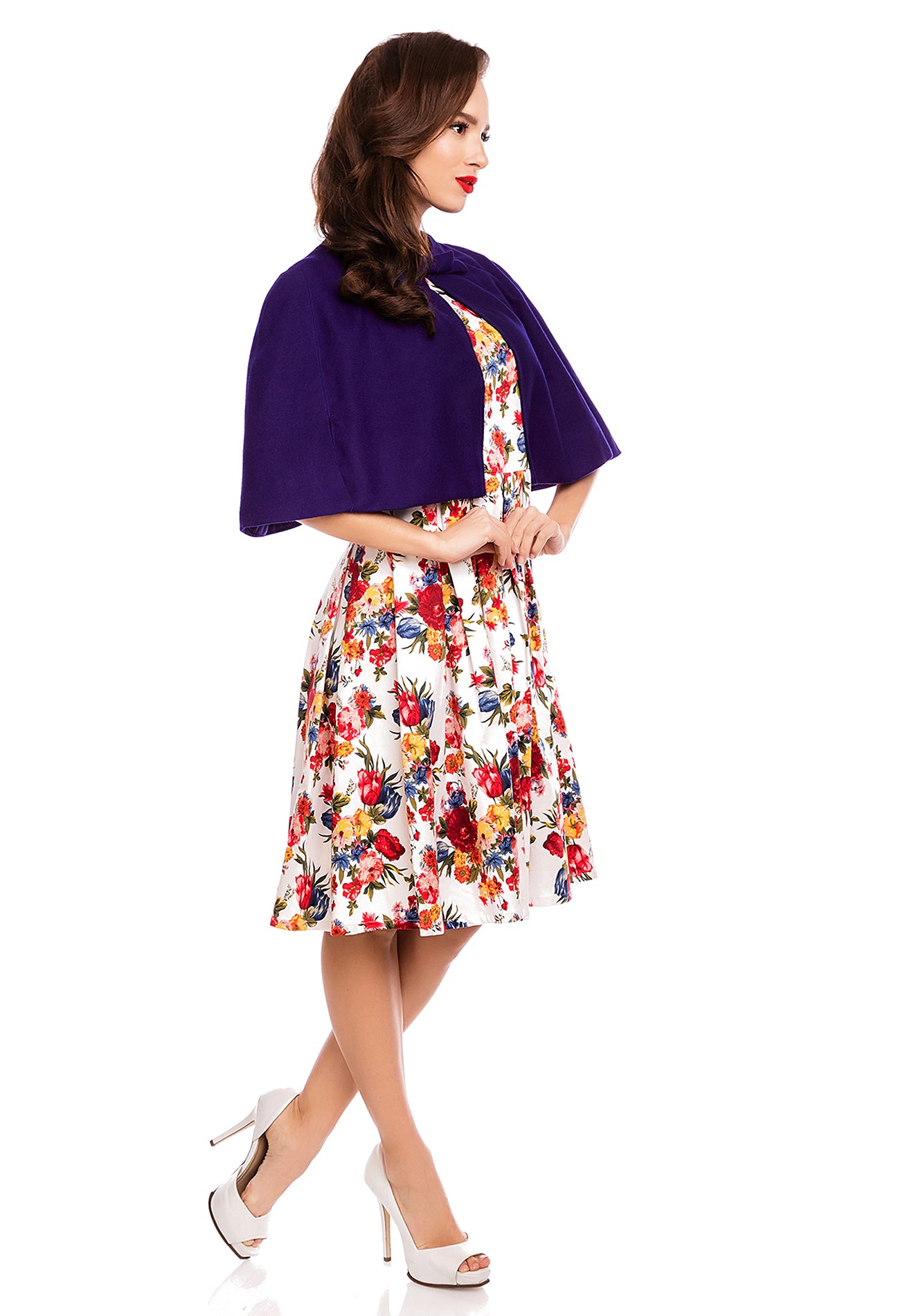 Model wearing our dark blue Sabrina cape shrug, over a white floral dress, side view