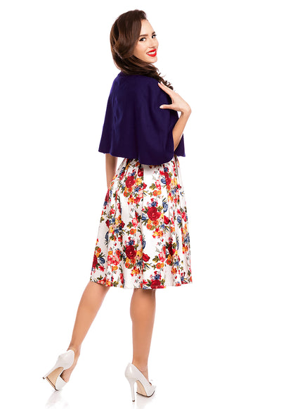 Model wearing our dark blue Sabrina cape shrug, over a white floral dress, back view