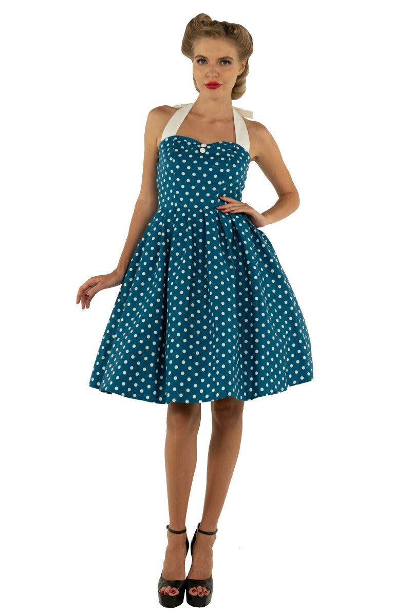 Model wears our halterneck Sophia dress, in blue, with white polka dots, front view