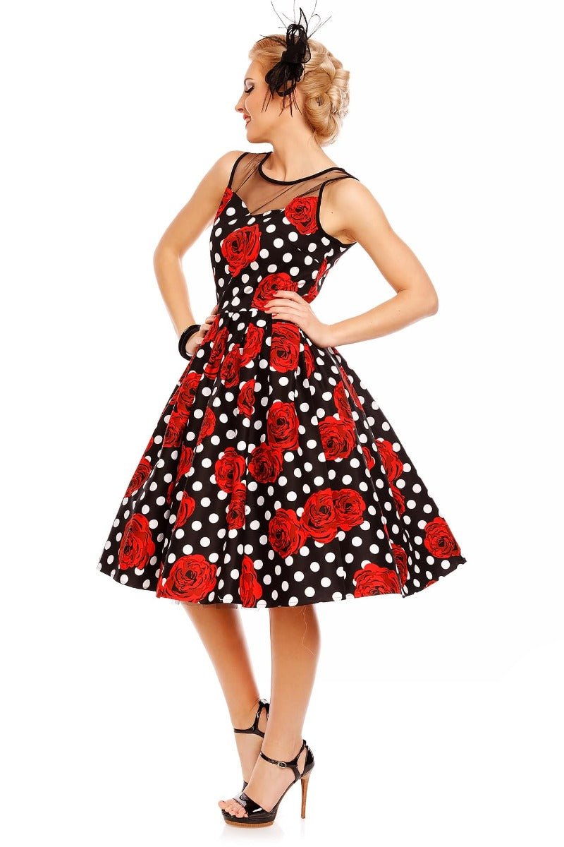Model wearing our Elizabeth black party dress, with red roses and white spots, side view