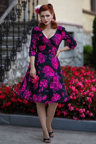 Model wearing v neck sleeved dress in black and pink floral print