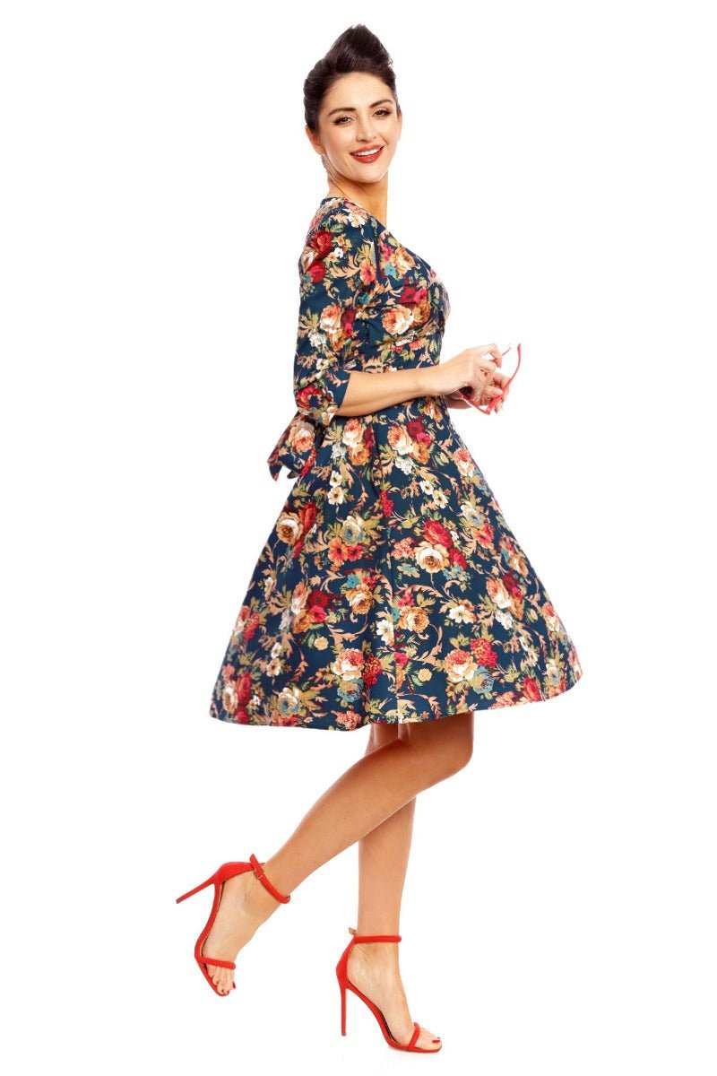 Model wearing our Katherine long sleeved swing dress, in dark blue/red floral print, side view