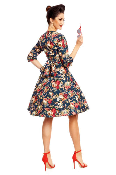 Model wearing our Katherine long sleeved swing dress, in dark blue/red floral print, back view