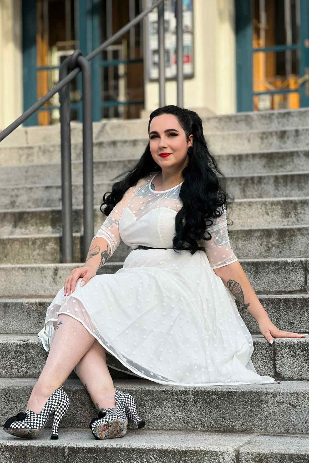 Customer wears our Madeline lace white vintage bridal dress and sits on steps