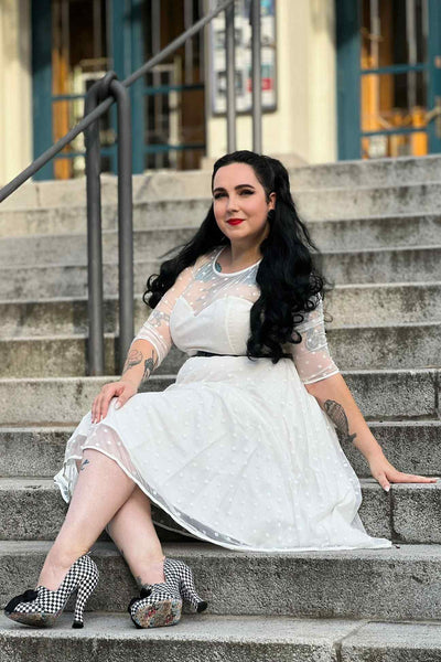 Customer wears our Madeline lace white vintage bridal dress and sits on steps
