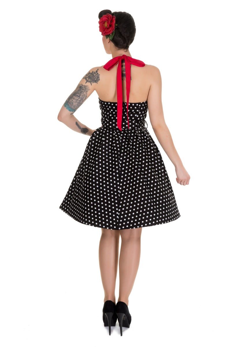 Model wearing halterneck dress in black and white polka dots back view